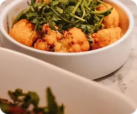 Crispy Cauliflower Appetizer with Fresh Greens at an Indian Restaurant