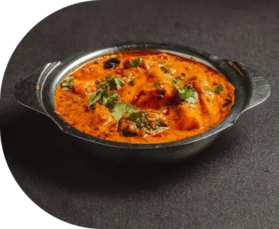Rich, creamy Indian curry served with herbs at a South Indian restaurant