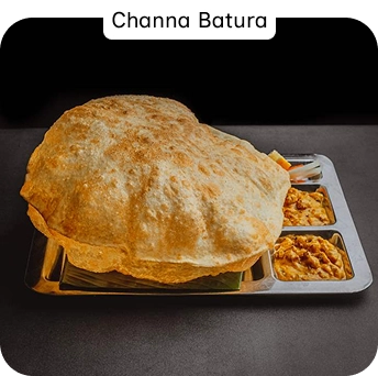 Channa Bhatura Served With Chickpea Curry and Sides at an Indian Restaurant In Croydon
